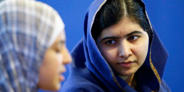 Malala Yousefzai (R) listens to 17 year old Syrian refugee Muzoon Almellehan speak to journalists at the City Library in Newcastle Upon Tyne, Britain December 22, 2015. Nearly two years after they met in a dust-blown refugee camp in Jordan, Nobel laureate Malala Yousafzai welcomed Syrian fellow schoolgirl activist Muzoon Almellehan to her friend's new home in rainy northern England on Tuesday. REUTERS/Darren Staples