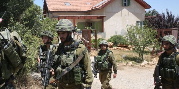 Israeli soldiers stand guard outside a house in the Jewish settlement of Kiryat Arba in the occupied West Bank where a 13-year-old Israeli girl was fatally stabbed in her bedroom on June 30, 2016.A Palestinian attacker stabbed a 13-year-old girl to death at her home in the Jewish settlement outside the city of Hebron before being shot dead by security guards, the Israeli army said. / AFP / MENAHEM KAHANA (Photo credit should read MENAHEM KAHANA/AFP/Getty Images)