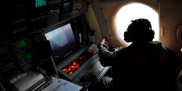 U.S. Navy LT. JG Dylon Porlas looks out the window of a U.S. Navy Lockheed P-3C Orion patrol aircraft from Sigonella, Sicily, Sunday, May 22, 2016, searching the area in the Mediterranean Sea where the Egyptair flight 804 en route from Paris to Cairo went missing on May 19. Search crews found floating human remains, luggage and seats from the doomed EgyptAir jetliner Friday but face a potentially more complex task in locating bigger pieces of wreckage and the black boxes vital to determining why the plane plunged into the Mediterranean. (AP Photo/Salvatore Cavalli)