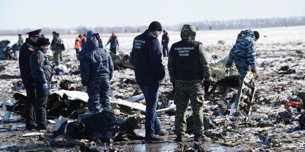 Russian Investigative Committee employees, center, and police officers investigate the wreckage of a crashed plane at the Rostov-on-Don airport, about 950 kilometers (600 miles) south of Moscow, Russia, Sunday, March 20, 2016. Winds were gusting before dawn Saturday over the airport in the southern Russian city of Rostov-on-Don when a plane carrying 62 people from a favorite Russian holiday destination decided to abort its landing. (AP Photo)