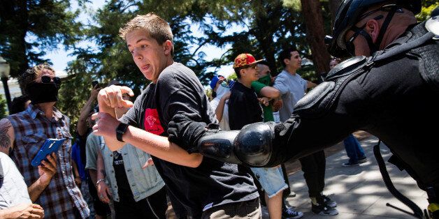 A police officer grabs a man antagonizing