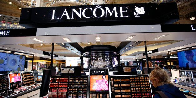 A woman stands in front of a Lancome counter, the cosmetics and perfume brand of French cosmetics group L'Oreal, at a department store in Paris April 20, 2015. L'Oreal posted a 14.1 percent rise in first-quarter sales on Monday, helped by the weak euro and resilient demand for luxury goods products such as Yves Saint Laurent's Black Opium perfume. REUTERS/Charles Platiau