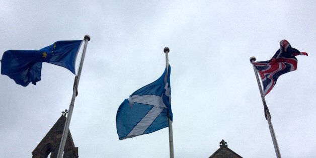 In this picture taken on Thursday, May 26, 2016, an EU flag, a Scottish flag and an Union Jack, left to right, wave outside Scottish parliament in front âThe Queenâs Galleryâ in Edinburgh. Scottish voters who want Britain to remain part of the EU would be so unhappy if it decided to break away that they would back a second referendum on forming their own independent nation. (AP Photo/ Dorothee Thiesing)