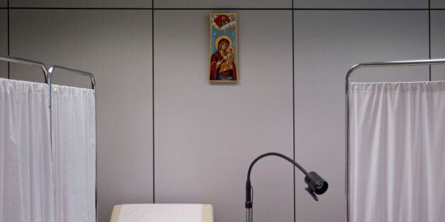 An icon depicting Virgin Mary holding Jesus Christ is seen inside a medical centre which has been set up by volunteers at the headquarters of the Athens Medical Association with the contribution of the Greek Orthodox Church in Athens May 25, 2012. Greece's rundown state hospitals are cutting off vital drugs, limiting non-urgent operations and rationing even basic medical materials for exhausted doctors as a combination of economic crisis and political stalemate strangle health funding. With Greece now in its fifth year of deep recession, trapped under Europe's biggest public debt burden and dependent on international help to keep paying its bills, the effects are starting to bite deeply into vital services. Picture taken May 25, 2012. REUTERS/Yorgos Karahalis (GREECE - Tags: BUSINESS HEALTH SOCIETY RELIGION) ATTENTION EDITORS: PICTURE 14 of 25 FOR PACKAGE 'GREEK HEALTH SYSTEM CRUMBLES'. SEARCH 'RUNDOWN STATE HOSPITALS' TO FIND ALL IMAGES