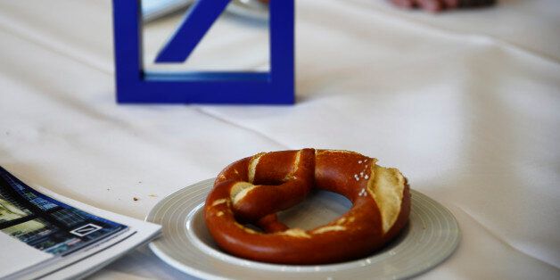The emblem of Deutsche Bank is pictured on a table next to a pretzel in the catering area during the bank's annual general meeting in Frankfurt, Germany, May 19, 2016. REUTERS/Kai Pfaffenbach