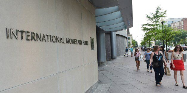Pedestrians pass by a headquarters building of the International Monetary Fund in Washington, DC on July 5, 2015. The euro was dropping against the dollar after early results of the Greece bailout referendum suggested the country rejected fresh austerity demands from EU-IMF creditors. AFP PHOTO/MANDEL NGAN (Photo credit should read MANDEL NGAN/AFP/Getty Images)