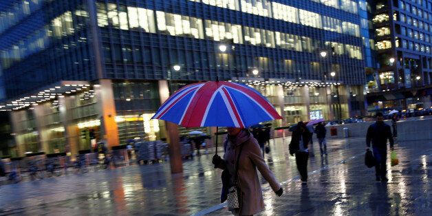 Workers walk in the rain at the Canary Wharf business district in London, Britain November 11, 2013. REUTERS/Eddie Keogh/File Photo