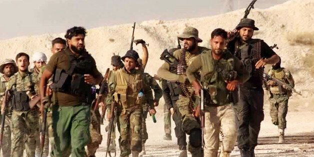 This file photo released Tuesday June 28, 2016 by the New Syrian Army, an anti-government rebel group, which has been authenticated based on its contents and other AP reporting, shows U.S.-backed Syrian rebels of the New Syrian Army running in an unknown place in Syria. A humiliating defeat came Wednesday, June 29, 2016 for the New Syrian Army's offensive to capture Boukamal, a prize possession of the Islamic State group and their last border crossing between Iraq and Syria. The quick unraveling of the budding offensive reflects the difficulties in U.S. efforts to create an effective Syrian force against IS. (The New Syrian Army via AP, File)