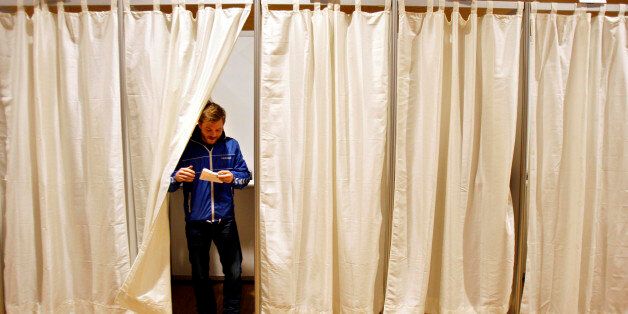 A Icelandic man seen exiting a booth after casting his preliminary vote, open to those unable to vote Saturday, in Reykjavik, Iceland, Friday, April 24, 2009. Icelanders vote in an early parliamentary election Saturday and are expected to turn their backs on the lawmakers who were in charge when the tiny Nordic nation's financial system collapsed last year. (AP Photo/Brynjar Gauti)