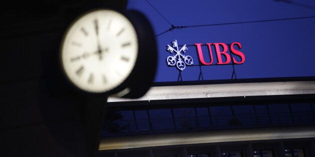 A sign sits illuminated on the roof of the UBS Group AG headquarters in Zurich, Switzerland, on Monday, May 2, 2016. UBS said first-quarter profit plunged 64 percent, missing analyst estimates, as market turbulence eroded earnings at the wealth-management and securities units. Photographer: Matthew Lloyd/Bloomberg via Getty Images