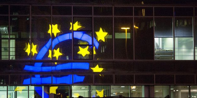 The euro sign sculpture is reflected in office windows as it stands outside the former European Central Bank (ECB) headquarters, at night in Frankfurt, Germany, on Wednesday, Jan. 27, 2016. German domestic demand, buoyed by a stable labor market and low oil prices, will propel the country's economic growth this year and compensate for slowing exports as emerging economies stumbles. Photographer: Krisztian Bocsi/Bloomberg via Getty Images