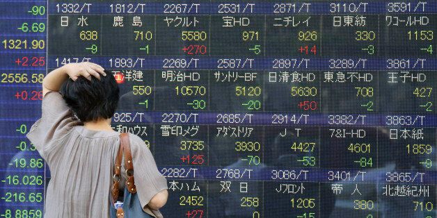 A woman looks at an electronic stock board of a securities firm in Tokyo, Friday, June 10, 2016. Asian stock markets slipped Friday in holiday-thinned trading as investors shied away from risky assets before the release of Chinese economic data and a Fed policy meeting, and as fears loomed that Britain could vote to leave the European Union. (AP Photo/Koji Sasahara)