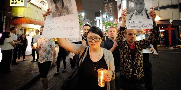 TOKYO, JAPAN - JUNE 14 : People pay tribute to victims of shooting at Pulse Nightclub in Orlando by holding banners and lighting candles, on June 14, 2016 at Shinjuku Ni-chome neighborhood of Tokyo, Japan. Omar Mateen opened fire at the Pulse nightclub early Sunday, killing 49 people and wounding 53 others before dying in a shootout with police. (Photo by DAVID MAREUIL/Anadolu Agency/Getty Images)