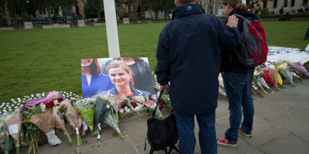 People look at tributes for Jo Cox, the 41-year-old British Member of Parliament shot to death yesterday in northern England, on Parliament Square outside the House of Parliament in London, Friday, June 17, 2016. The mother of two young children was shot to death Thursday afternoon in her constituency near Leeds. A 52-year-old man has been arrested but has not been charged. (AP Photo/Matt Dunham)