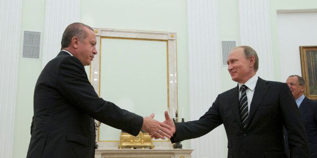Russian President Vladimir Putin shakes hands with Turkey's President Recep Tayyip Erdogan, left, in Moscow's Kremlin, Russia, Wednesday, Sept. 23, 2015. Putin was joined at Wednesday's ceremonial opening of the Russian capital's new main mosque, by Erdogan and Palestinian President Mahmoud Abbas. (AP Photo/Ivan Sekretarev, Pool)