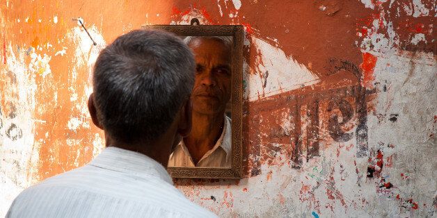 KOLKATA, WEST BENGAL, INDIA, CALCUTTA, WEST BENGAL, INDIA - 2011/10/31: Man looking at the mirror in a street barbershop in Kolkata (Calcutta). West Bengal, India. (Photo by Marji Lang/LightRocket via Getty Images)