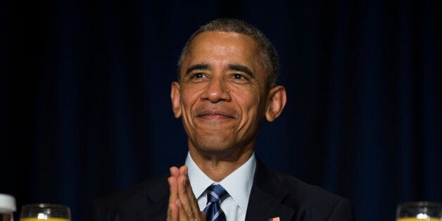 President Barack Obama bows his head towards the Dalai Lama as he was recognized during the National Prayer Breakfast in Washington, Thursday, Feb. 5, 2015. The annual event brings together U.S. and international leaders from different parties and religions for an hour devoted to faith. (AP Photo/Evan Vucci)