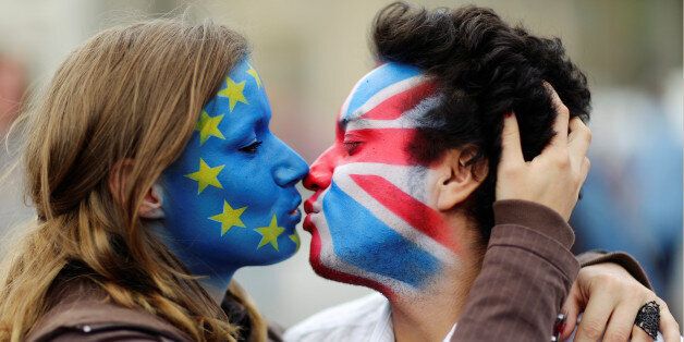 Two activists with the EU flag and Union Jack painted on their faces kiss each other in front of Brandenburg Gate to protest against the British exit from the European Union, in Berlin, Germany, June 19, 2016. REUTERS/Hannibal Hanschke
