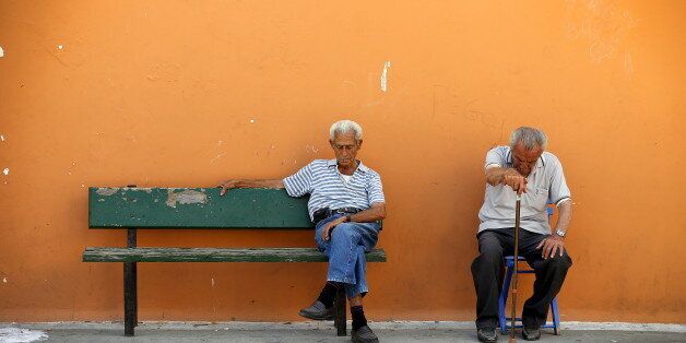 Two men sit on a bench in the village of Meyisti on the Island of Kastellorizo, Greece, July 4, 2015. It was on this island, that former Prime Minister George Papandreou announced in 2010 that Greece required a rescue package. If a 'No' in Sunday's referendum eventually takes Greece out of Europe's single currency, any