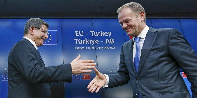 Turkish Prime Minister Ahmet Davutoglu (L) shakes hands with European Council President Donald Tusk after a news conference at the end of a EU-Turkey summit in Brussels March 8, 2016. REUTERS/Yves Herman TPX IMAGES OF THE DAY