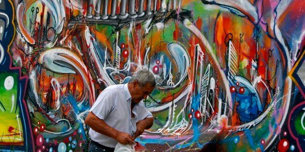 A man walks past a graffiti depicting the economic situation in Europe, in Lisbon August 22, 2011. Turbulent...