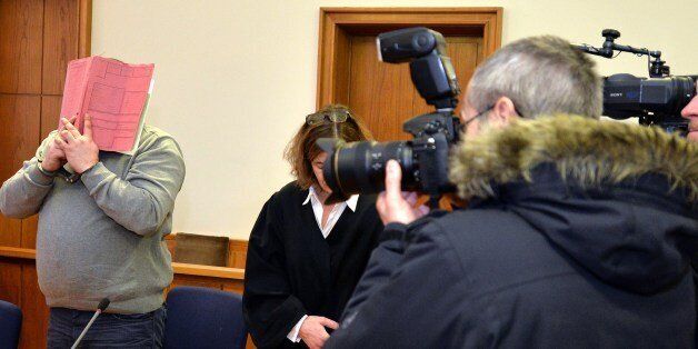 German former male nurse Niels H (L) hides his face behind a folder as he waits for the opening of another session of his trial on February 26, 2015 at court in Oldenburg, northwestern Germany. A verdict is expected in the case in which the 38-year-old nurse had admitted killing over 30 hospital patients with lethal injections in a thrill-seeking game to try to revive them. AFP PHOTO / DPA / CARMEN JASPERSEN +++ GERMANY OUT (Photo credit should read CARMEN JASPERSEN/AFP/Getty Images)