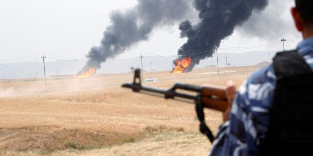 A member of the Kurdish security forces stands guard after explosions at two oil wells in Khabbaz oilfield, 20 km (12 miles) southwest of Kirkuk in Iraq, May 4, 2016. REUTERS/Ako Rasheed