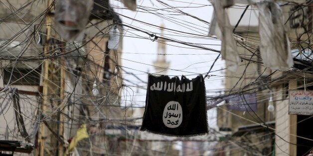 An Islamic State flag hangs amid electric wires over a street in Ain al-Hilweh Palestinian refugee camp, near the port-city of Sidon, southern Lebanon January 19, 2016. REUTERS/Ali Hashisho