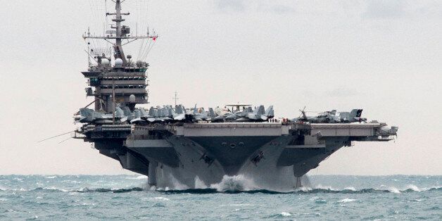 In this Saturday, Dec. 26, 2015 photo released by the U.S. Navy, the aircraft carrier USS Harry S. Truman transits the Strait of Hormuz. Iran flew a surveillance drone over a U.S. aircraft carrier and took
