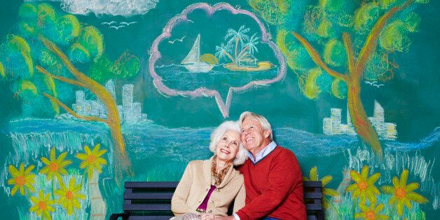 An elderly couple daydreaming on a park bench.