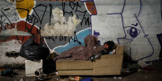 A homeless person covered in a blanket rests on a sofa on the street, on a cold night in Sao Paulo, Brazil, June 13, 2016. REUTERS/Nacho Doce