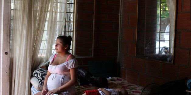 A pregnant woman sits on a bed with her cousin after being released from the hospital where she was treated for the Zika virus in Cucuta, Colombia, on Sunday, Feb. 7, 2016. Alejandro Gaviria, Colombia's health minister, says the country has nearly 20,500 cases of the mosquito-borne Zika virus. Photographer: Dania Maxwell/Bloomberg via Getty Images
