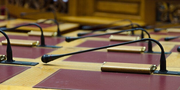 The desks and microphones inside the empty Greek Parliament