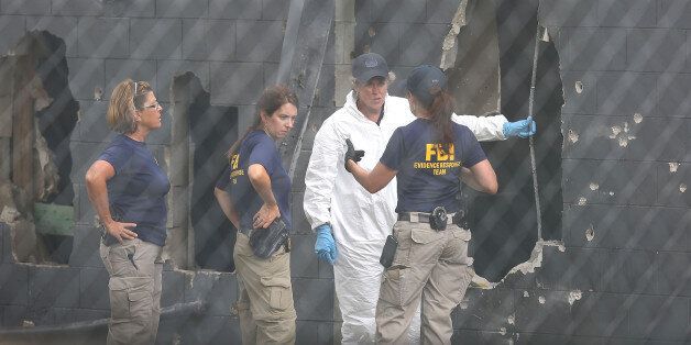 ORLANDO, FL - JUNE 12: FBI agents investigate near the damaged rear wall of the Pulse Nightclub where Omar Mateen allegedly killed at least 50 people on June 12, 2016 in Orlando, Florida. The mass shooting killed at least 50 people and injuring 53 others in what is the deadliest mass shooting in the country's history. (Photo by Joe Raedle/Getty Images)