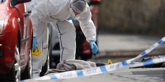 A forensics police officer works next women's shoes and a handbag on the ground behind a police cordon in Birstall near Leeds, June 16, 2016 A British lawmaker was in critical condition after an incident in her constituency in northern England on Thursday, British police said, with media reports suggesting she had been shot and stabbed. Media reports said Jo Cox, 41, who is a lawmaker for the opposition Labour Party, had been attacked as she prepared to hold an advice surgery for constituents in Birstall near Leeds. REUTERS/Phil Noble