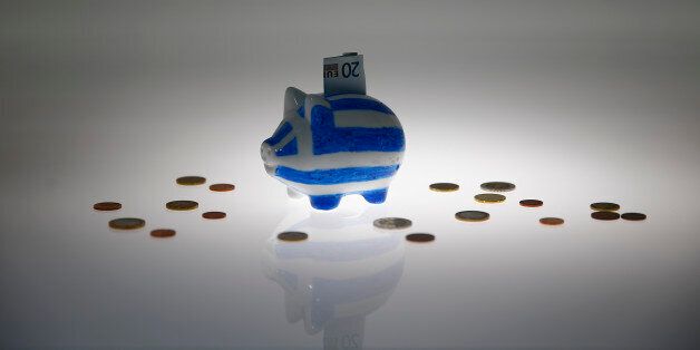 A piggybank painted in the colours of the Greek flag with a 20 euro banknote in it's slot, stands amongst various euro coins in this picture illustration taken in Berlin, Germany June 30, 2015. The head of the European Commission made a last-minute offer to try to persuade Greek Prime Minister Alexis Tsipras to accept a bailout deal he has rejected before a referendum on Sunday which EU partners say will be a choice of whether to stay in the euro. But Greek government sources said the leftist premier stood by his rejection of the creditors' conditions and Greece would default on a crucial repayment due to the International Monetary Fund on Tuesday, plunging it deeper into financial crisis. REUTERS/Pawel Kopczynski