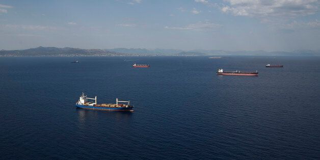 Oil tankers and container ships sit at their deepwater moorings in the Aegean sea off the coast of Athens, Greece, on Thursday, June 25, 2015. Greece could tap euro-area funds of as much as 3.35 billion euros ($3.75 billion) by early July if it can reach a deal with its creditors, thanks to profit-sharing pledges from member nations' central banks. Photographer: Simon Dawson/Bloomberg via Getty Images