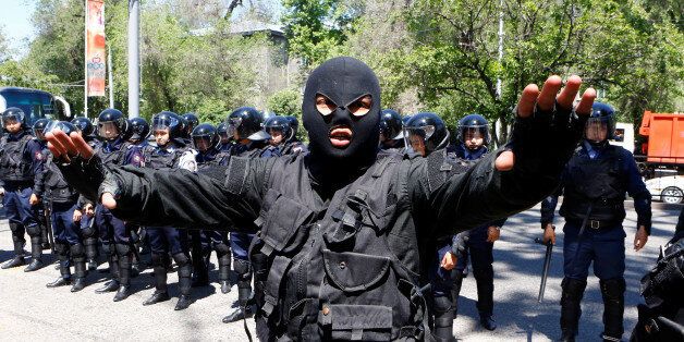 A riot police officer gestures during a protest against President Nursultan Nazarbayev's government and an unpopular land reform it has proposed, in Almaty, Kazakhstan, May 21, 2016. REUTERS/Shamil Zhumatov