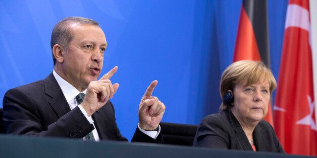 German Chancellor Angela Merkel, right, listens as Turkey's Prime Minister Recep Tayyip Erdogan, left, speaks during a joint press conference after a meeting at the chancellery in Berlin, Germany, Tuesday, Feb. 4, 2014. (AP Photo/Axel Schmidt)