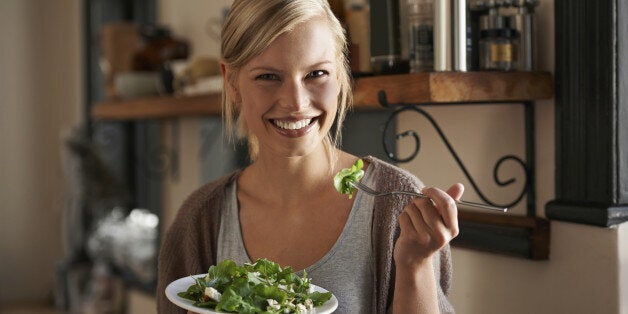 Portrait of an attractive young woman eating a salad in her kitchen