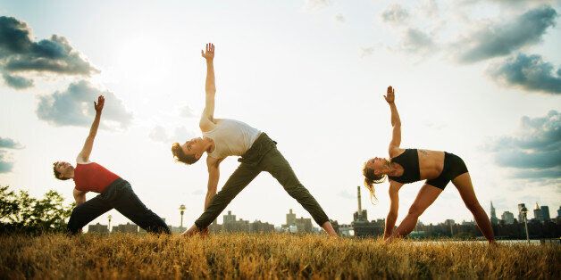 Young fit people doing yoga in the East River Park in Williamsburg, Brooklyn, New York City