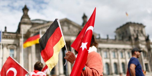 Demonstrators hold Turkish and German flags in front of the Reichstag, the seat of the lower house of parliament Bundestag in Berlin, Germany, June 1, 2016, as they protest against a disputed vote in Germany's parliament on Thursday, on a resolution that labels the killings of up to 1.5 million Armenians by Ottoman forces as genocide. REUTERS/Hannibal Hanschke