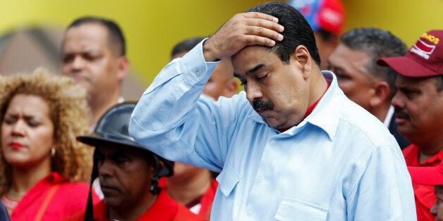 Venezuela's President Nicolas Maduro wipes his face as he reads a document, during a rally with pro-government members of the public transport sector in Caracas, Venezuela May 31, 2016. REUTERS/Carlos Garcia Rawlins