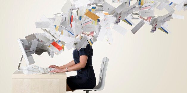 Businesswoman's head covered with flying paperwork