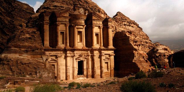 In this Feb. 23, 2016 photo, sun peaks out of rain clouds to light up the famous monastery in Petra southern Jordan. The Nabatean ruins are famous worldwide. (AP Photo/Sam McNeil)