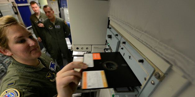 GREAT FALLS, MONTANA, 2014 - Missile combat crew member 1st Lt. Katie Grimley slides a large floppy disk into a 60's era communication module inside the launch control center of a missile alert facility at Malmstrom Air Force Base. The U.S. govt. is embarking on a $400 billion modernization to its nuclear weapons arsenal. (Photo by Robert Gauthier/Los Angeles Times via Getty Images)