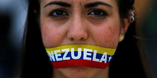 An opposition supporter covers her mouth during a rally to demand a referendum to remove President Nicolas Maduro in Caracas, Venezuela, June 7, 2016. REUTERS/Ivan Alvarado