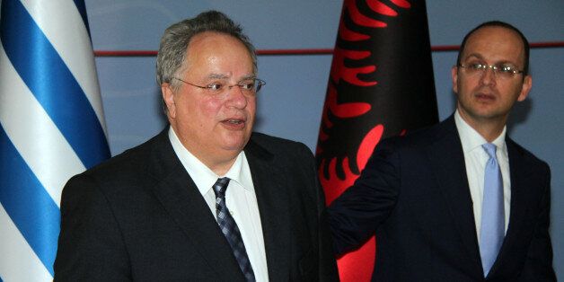 Albanian Foreign Minister Ditmir Bushati, right, accompanies visiting Greek counterpart Nikos Kotzias while hundreds of the Cham community members, expelled from northwestern Greece during World War II after Athens claimed they had collaborated with the country's German occupiers, hold a protest outside, Tirana Monday, June 6, 2016. Four issues have turned bilateral ties sour between the neighbors: the Chams' claims on their confiscated property; the technical state of war still in place since then-fascist Italy attacked Greece through Albania in 1940; an unresolved maritime dispute and Greek claims of discrimination against the ethnic Greek minority in Albania.(AP Photo/Hektor Pustina)