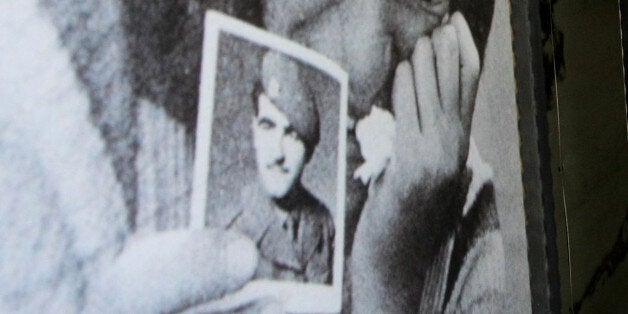 A couple stand in front of a giant poster depicting a Greek Cypriot girl holding a picture of her father, who has been missing since the Turkish invasion of 1974 in Ledra main street in divided Nicosia, Cyprus, Thursday, June 18, 2009. The Netherlands on Thursday donated â¬250,000 ($346,000) to United Nations-led experts seeking the remains of Cypriots missing since ethnic violence decades ago on the divided island. The Netherlands donated the same amount last year. Around 1,470 Greek Cypriots and 500 Turkish Cypriots vanished during intercommunal fighting in the early 1960's and the 1974 Turkish invasion that ethnically split the island in response to a short-lived coup by supporters of union with Greece. (AP Photo/Petros Karadjias)