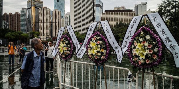 HONG KONG - JUNE 04: People walk past flowers at Victoria Park before the candlelight vigil on June 4, 2016 in Hong Kong, Hong Kong. Thousands of people in Hong Kong participated in an annual candlelight vigil in Hong Kong on June 4 to commemorate the killing of protesters in Beijing's Tiananmen Square in 1989. (Photo by Lam Yik Fei/Getty Images)